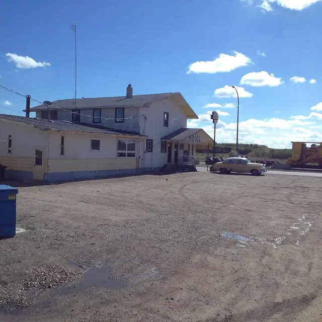 Hotel and gravel lot with vintage car